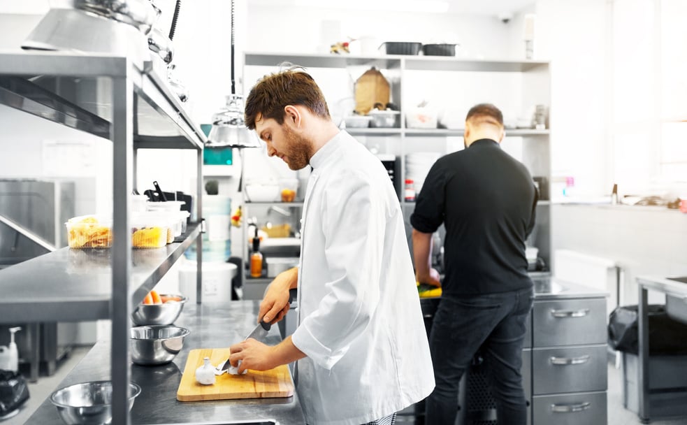 Chef and Cook Cooking Food at Restaurant Kitchen